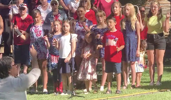 Photograph of Joyful Noise Carson Children's Choir directed by Michelle Powers performing 
  in Genoa on July 4, 2022